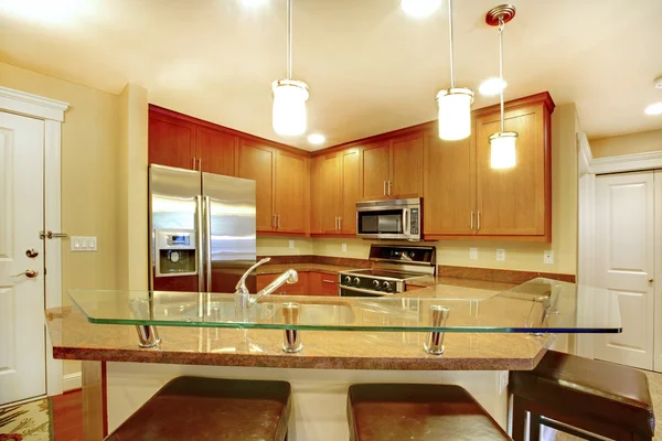 Interior de la cocina de marfil con armarios marrones y electrodomésticos de acero inoxidable . — Foto de Stock