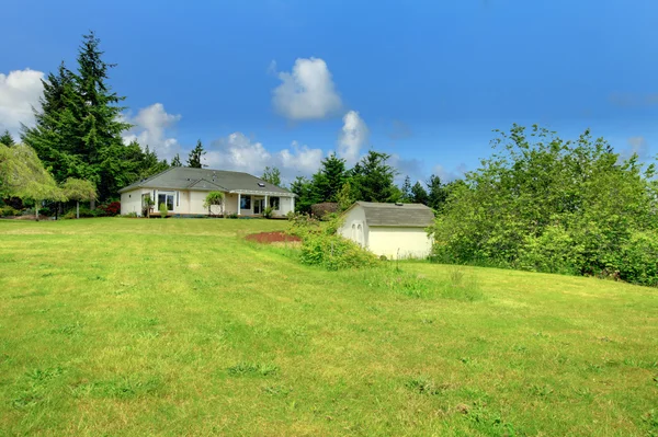 Gårdshus bakgård med en liten skjul och grön gräsmatta. — Stockfoto