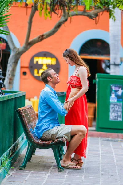 Woman in red dress standing opposite boyfriend. Outside — Stok fotoğraf