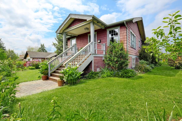 Big farmhouse with beautiful flowerbed, concrete walkway — Stock Photo, Image