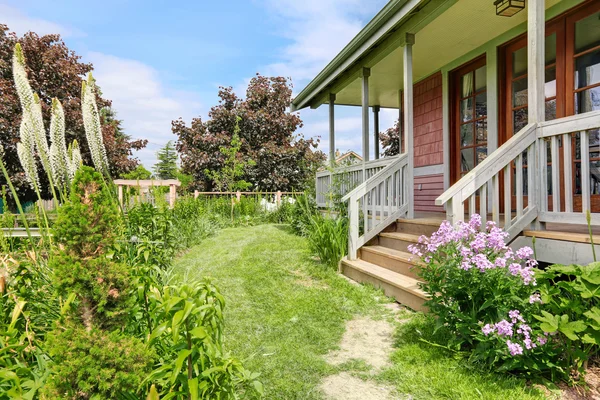 Hinterhof eines großen Bauernhauses mit schönem Blumenbeet — Stockfoto