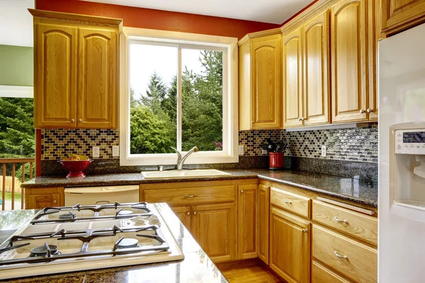Small kitchen with island, dark granite counter top — Stock Photo, Image