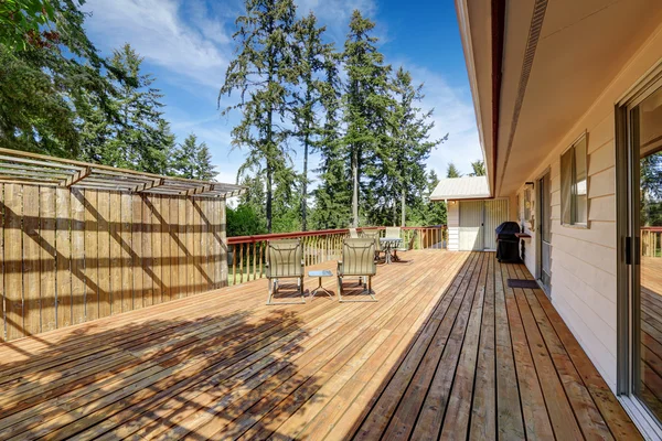Amplia terraza de madera con mesa de patio . — Foto de Stock