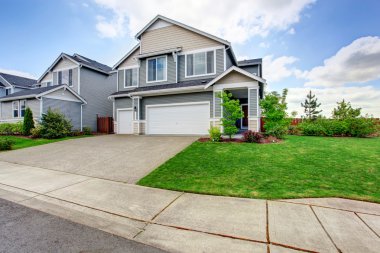 Siding, iki garaj alanları ve beton driveway ile büyük iki katlı ev