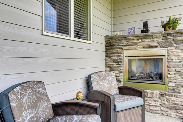 Cozy sitting area with two comfortable armchairs and fireplace with natural stone decor. — Stock Photo, Image