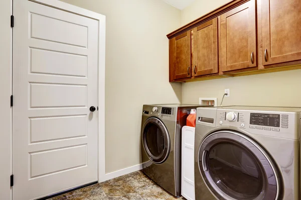 Laundry room with steel appliances and nice cabinets — Stock Photo, Image