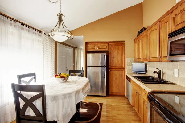 Cozinha acolhedora e sala de jantar interior com conjunto de mesa preta e armários castanhos . — Fotografia de Stock