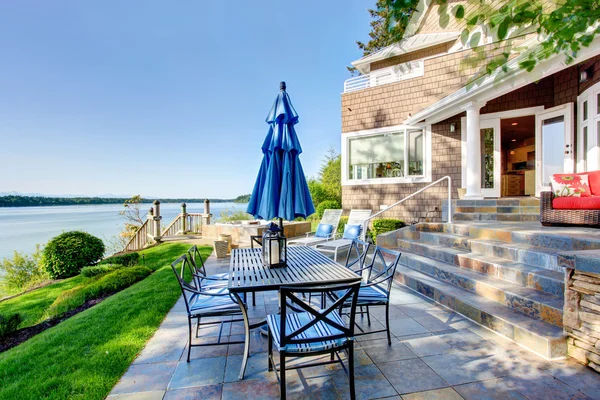 Casa de lujo exterior con impresionantes vistas al agua y acogedora zona de patio . — Foto de Stock