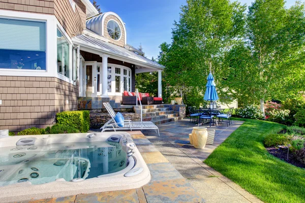 Luxury house exterior with impressive backyard design, patio area and hot tub. — Stock Photo, Image