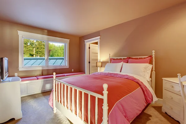 Aranyos lány szoba rózsaszín falak és piros ágynemű. — Stock Fotó