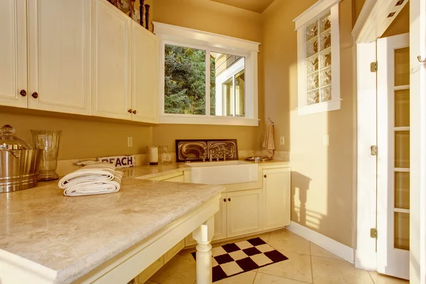 Lichte kamer keukenhoek met witte kasten, granieten teller boven- en tegel vloer — Stockfoto