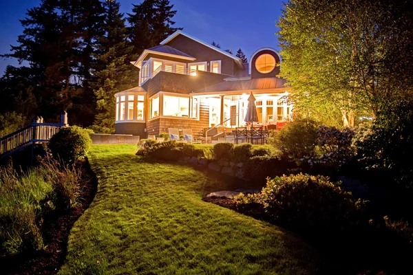 Großes zweistöckiges Haus mit vielen Lichtern am Sommerabend. — Stockfoto