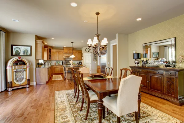 Classic American dining room with wooden table set, hardwood floor and rug. — Stock Photo, Image