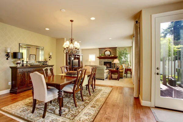 Sala de jantar americana clássica com conjunto de mesa de madeira, piso de madeira e tapete . — Fotografia de Stock