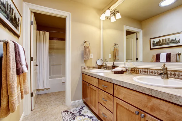 Élégant intérieur de salle de bain avec grand miroir, comptoir en granit et sol carrelage . — Photo