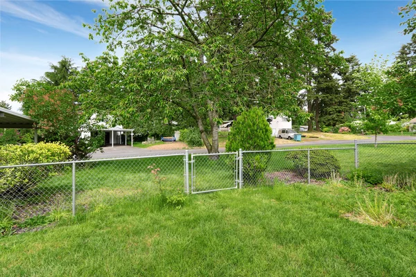 Blick auf eingezäunten Hinterhof mit viel Gras. — Stockfoto