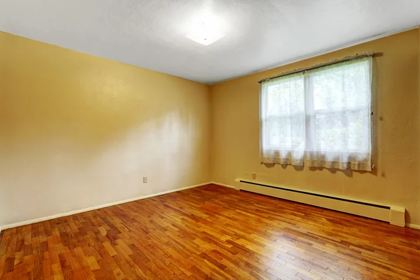 Petite salle de sous-sol vide avec parquet et murs beige — Photo