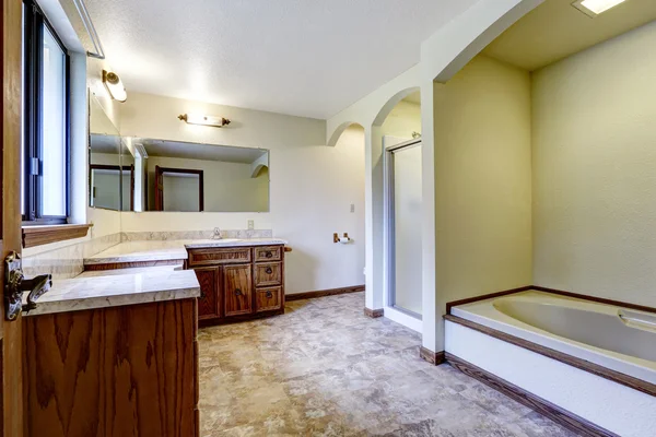 Intérieur de salle de bain de luxe avec armoires en bois et baignoire blanche — Photo