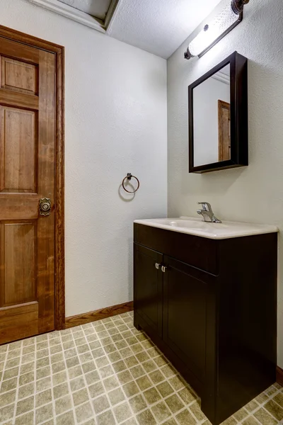 Intérieur de salle de bain simple avec armoires noires et évier blanc — Photo