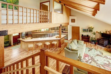 Merdivenlerden oturma odasına ve mutfak odasına bak. Tavanda ahşap kirişler. 