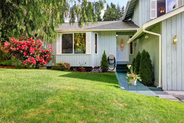 Casa azul americana com porta de entrada branca e gramado verde na frente da casa . — Fotografia de Stock