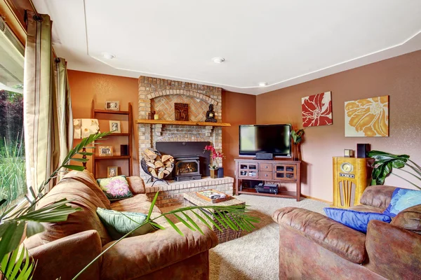 Půvabný obývací prostor v hnědých a bílých tónech. Krb s cihlovou stěnou. — Stock fotografie