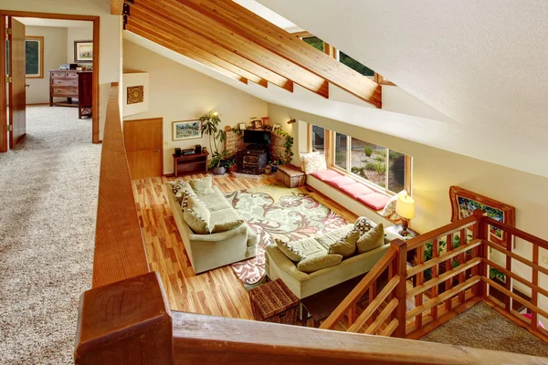 Pohled z chodby do obývacího pokoje ve stylu podkroví. Dřevěné trámy na stropě. — Stock fotografie
