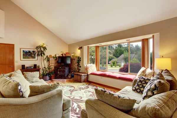 Living room interior with vaulted ceiling and cozy sitting place with red pillows. — Stock Photo, Image