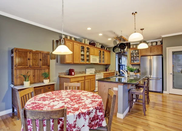 Kitchen with bright wooden cabinets, steel appliances and granite tops. — Stock Photo, Image