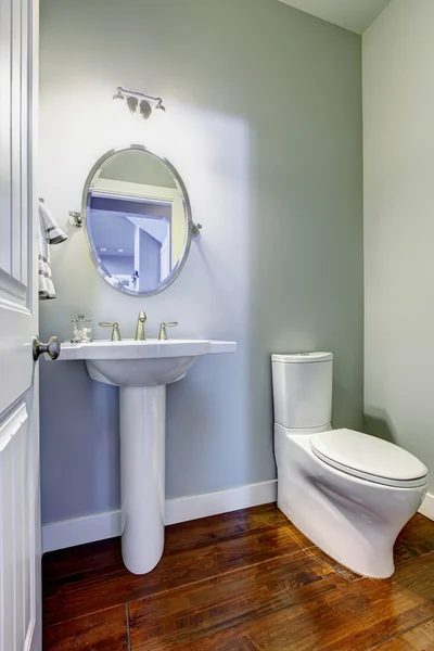 Interior do banheiro com piso de madeira e pia branca — Fotografia de Stock