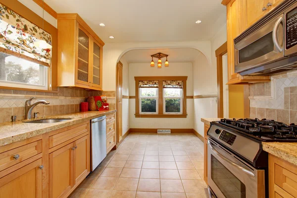 Luz tonos marrones cocina interior con suelo de baldosas y electrodomésticos de acero . — Foto de Stock