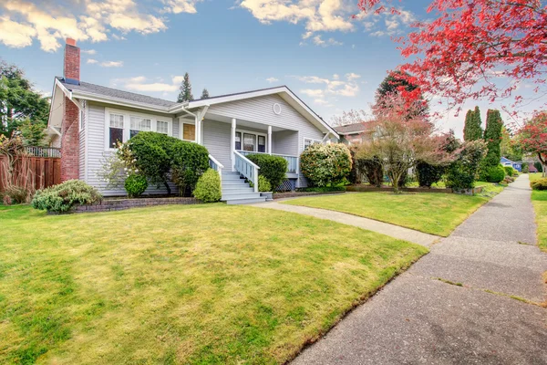 Beige siding huis exterieur met overdekte veranda en blauwe trap. — Stockfoto