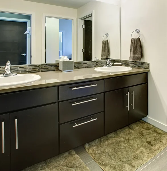 Interno bagno con armadi neri, due lavandini e grande specchio . — Foto Stock