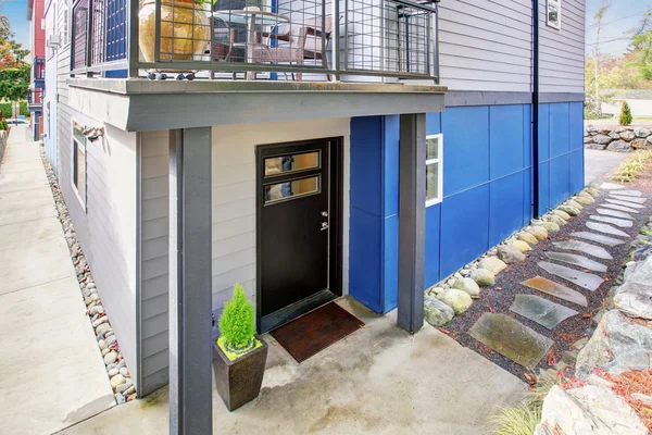 Czarne drzwi wejściowe zmodernizowanego mieszkania z naturalnym kamiennym chodnikiem. — Zdjęcie stockowe