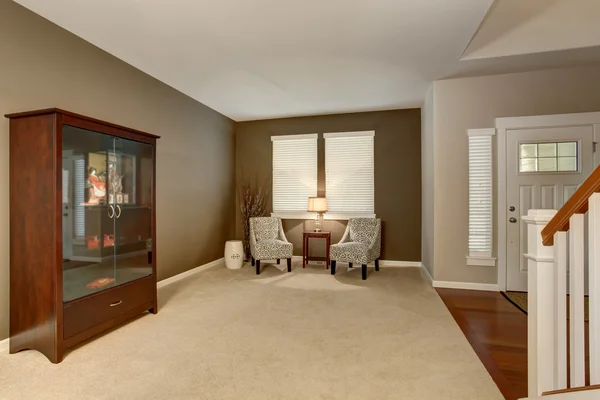 Elegant vardagsrum i bruna toner med två klassiska fåtöljer och ett fåfänga skåp. — Stockfoto