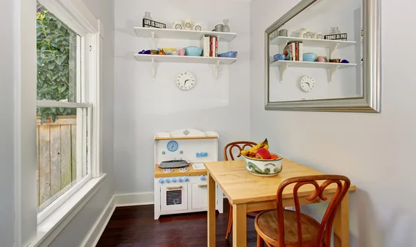 Pequeno mobiliário bonito na sala de jogos acolhedora crianças com paredes brancas e uma janela . — Fotografia de Stock