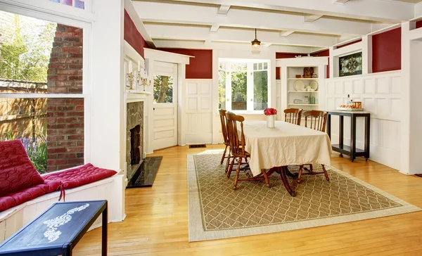 Helles Esszimmer mit roten Wänden und weißen Holzverkleidungen. — Stockfoto