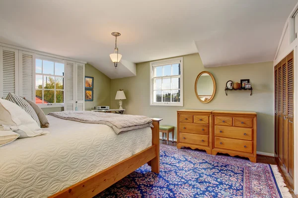 Ambiance cosy et confortable dans la chambre à coucher avec mobilier en bois et tapis coloré . — Photo