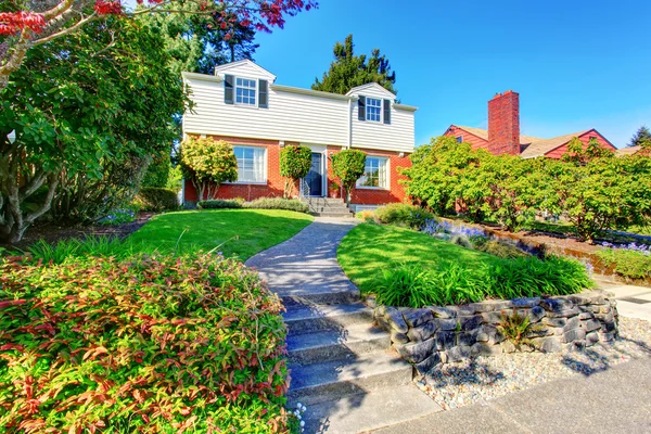 Gyönyörű megfékezésére két szintes ház szép első kert és beton sétány. . — Stock Fotó