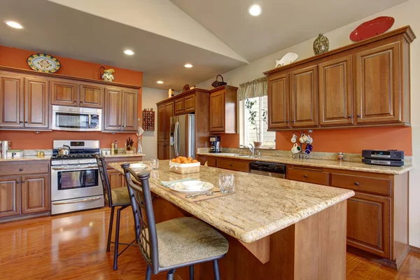 Braune Kücheneinrichtung mit Granitarbeitsplatten und Stahlgeräten. — Stockfoto