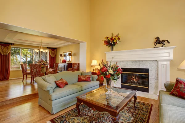 Élégant salon intérieur avec cheminée blanche et fleurs . — Photo
