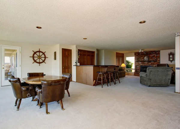豪华住宅的开放式平面图。用餐区，棕色桌子和带砖壁炉的客厅 — 图库照片