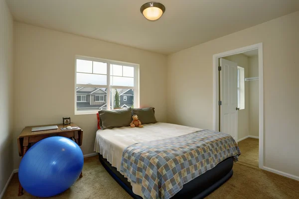 Маленькая детская спальня со столом, синим мячом и маленькой зеленой кроватью — стоковое фото