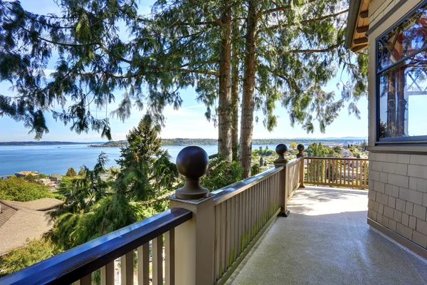 Grote ongemeubileerde veranda van luxe huis met uitzicht op het water. — Stockfoto