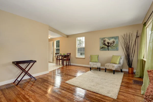 Cozy beige sitting room with shiny hardwood floor and dining area — Stock Photo, Image