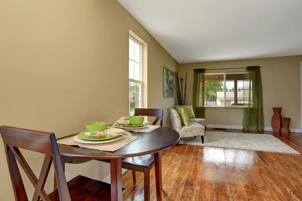 Mysig beige vardagsrum med glänsande trägolv och matplats — Stockfoto