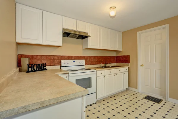 White kitchen room with tile floor and brown back splash tile. — Zdjęcie stockowe