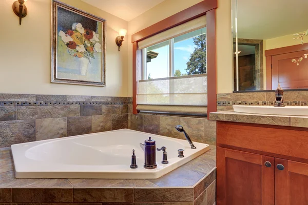 Linda casa de banho principal. Banheira branca com acabamento em azulejos de pedra . — Fotografia de Stock