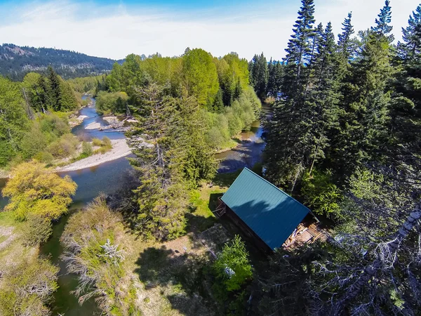 Vue panoramique de la maison de style cabine sur une rive de rivière — Photo