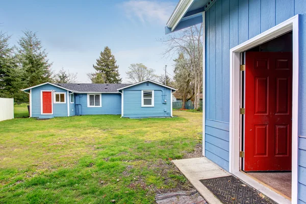 Achtertuin huis buitenkant met blauw en rood trim — Stockfoto